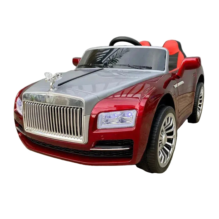 A red and silver toy ride-on car styled like a luxury Rolls-Royce, featuring a chrome grille, silver hood, and red body, parked on a concrete surface against a gray wall.