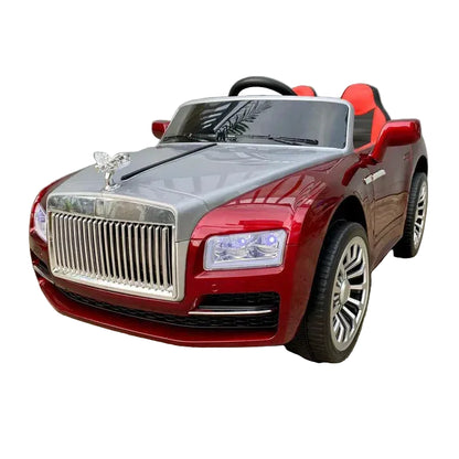 A red and silver toy ride-on car styled like a luxury Rolls-Royce, featuring a chrome grille, silver hood, and red body, parked on a concrete surface against a gray wall.